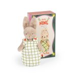 Muñeco de trapo "Bébé Nine" de Moulin Roty, un conejo con un vestido de cuadros, presentado fuera de su caja ilustrada de regalo.