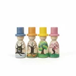 Set de 4 muñecos de madera con sombrero representando las estaciones del año estilo Waldorf. El modelo de primavera (derecha) tiene un sombrero rosa y un cerezo en flor pintado a mano sobre madera natural.